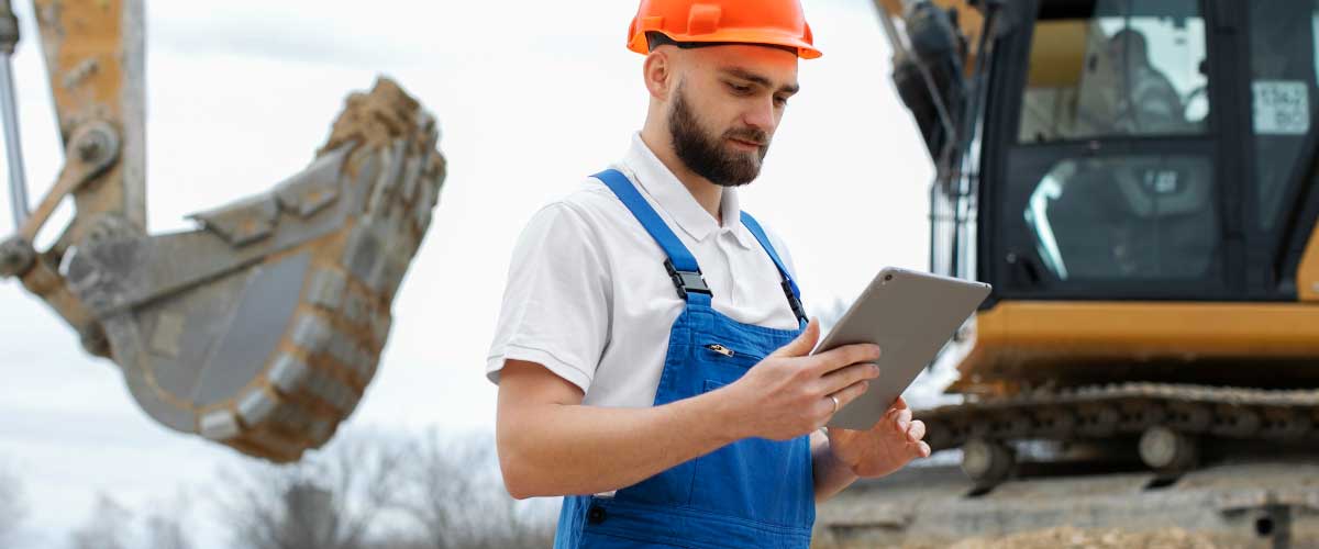 Bukósisakos dolgozó tabletet használ egy nagy építkezésen digitális adatrétegek megjelenítésével.